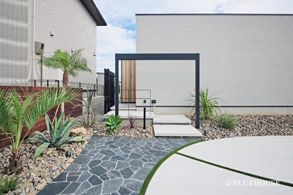 黒いゲートや南国風の植栽など、リゾートホテルのエントランスのような外構デザイン